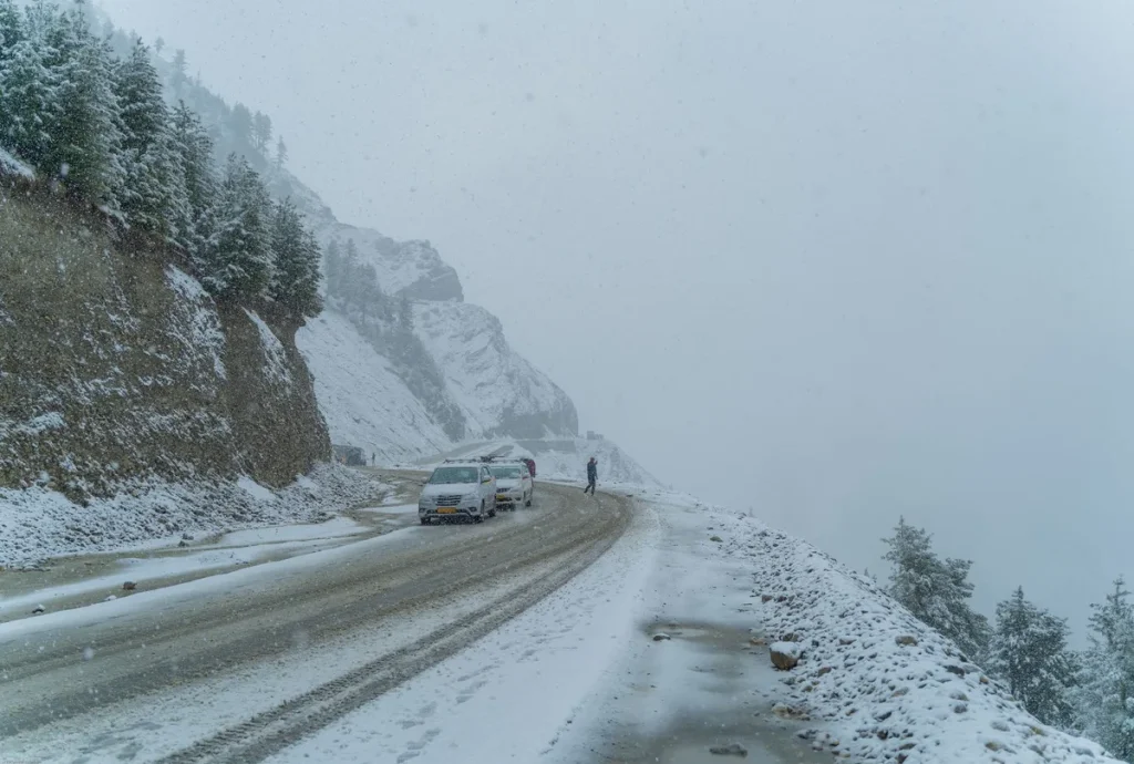 Camiones varados en un paso de montaña cubierto de nieve durante una tormenta de invierno en los Andes