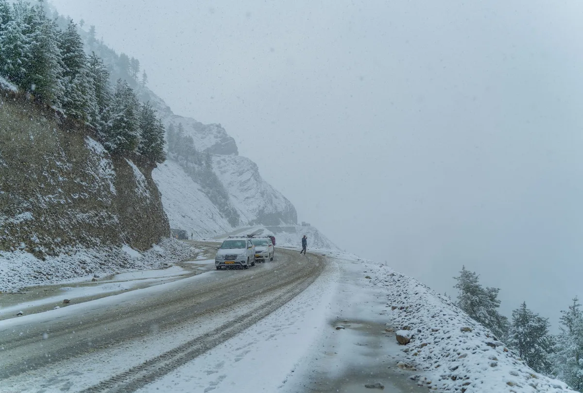 Camiones varados en un paso de montaña cubierto de nieve durante una tormenta de invierno en los Andes