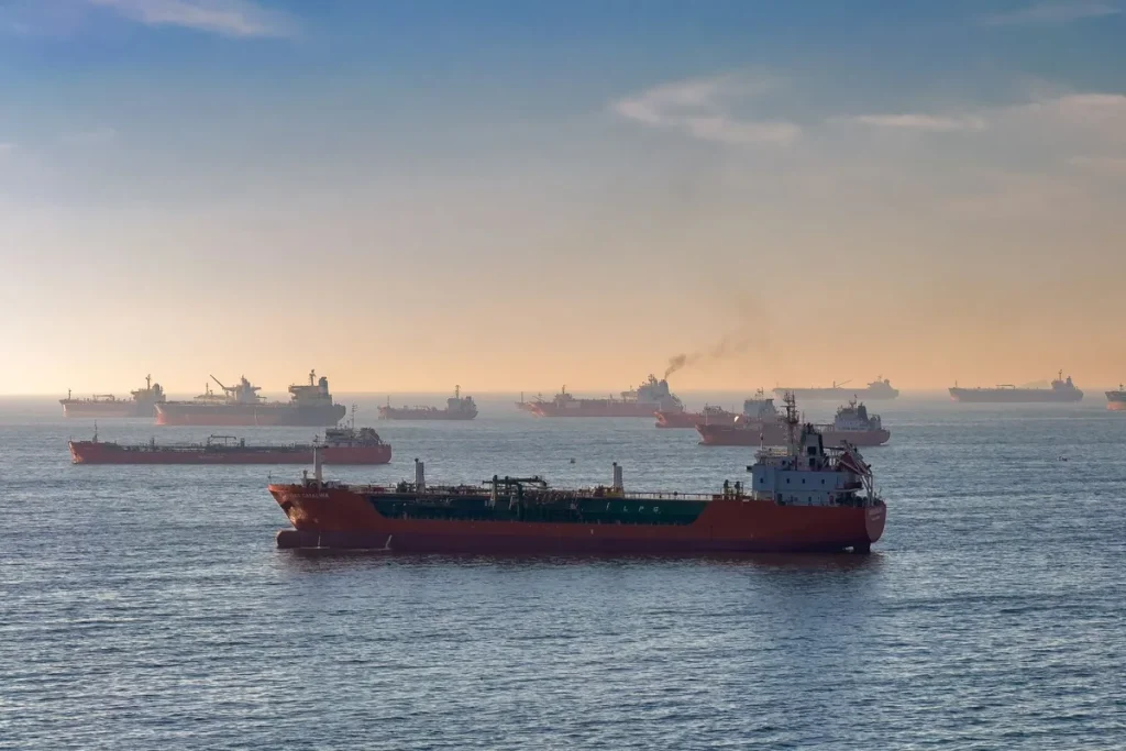 Cargo ship navigating a strategic maritime strait with oil tankers in the distance