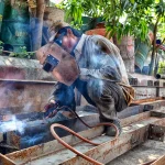 Trabajadores en línea de producción de cervecería monitoreando equipos e instalaciones industriales