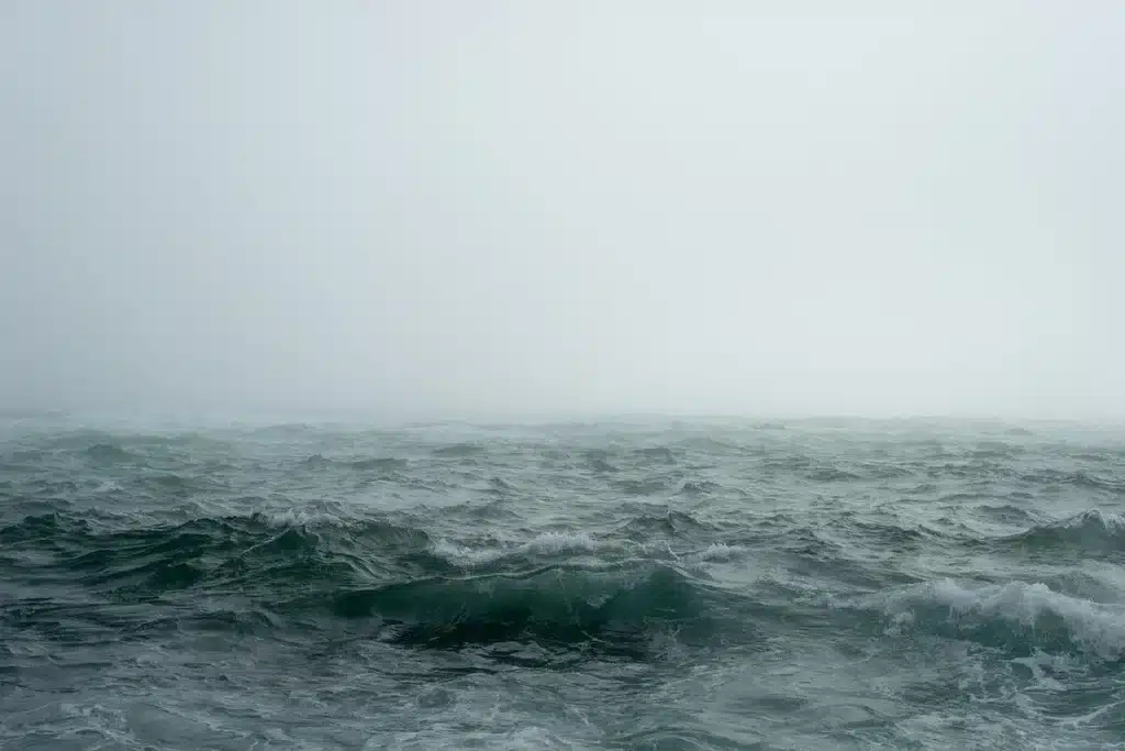Offshore supply vessels near rocky islands under foggy sky, suggesting South Atlantic logistics tension