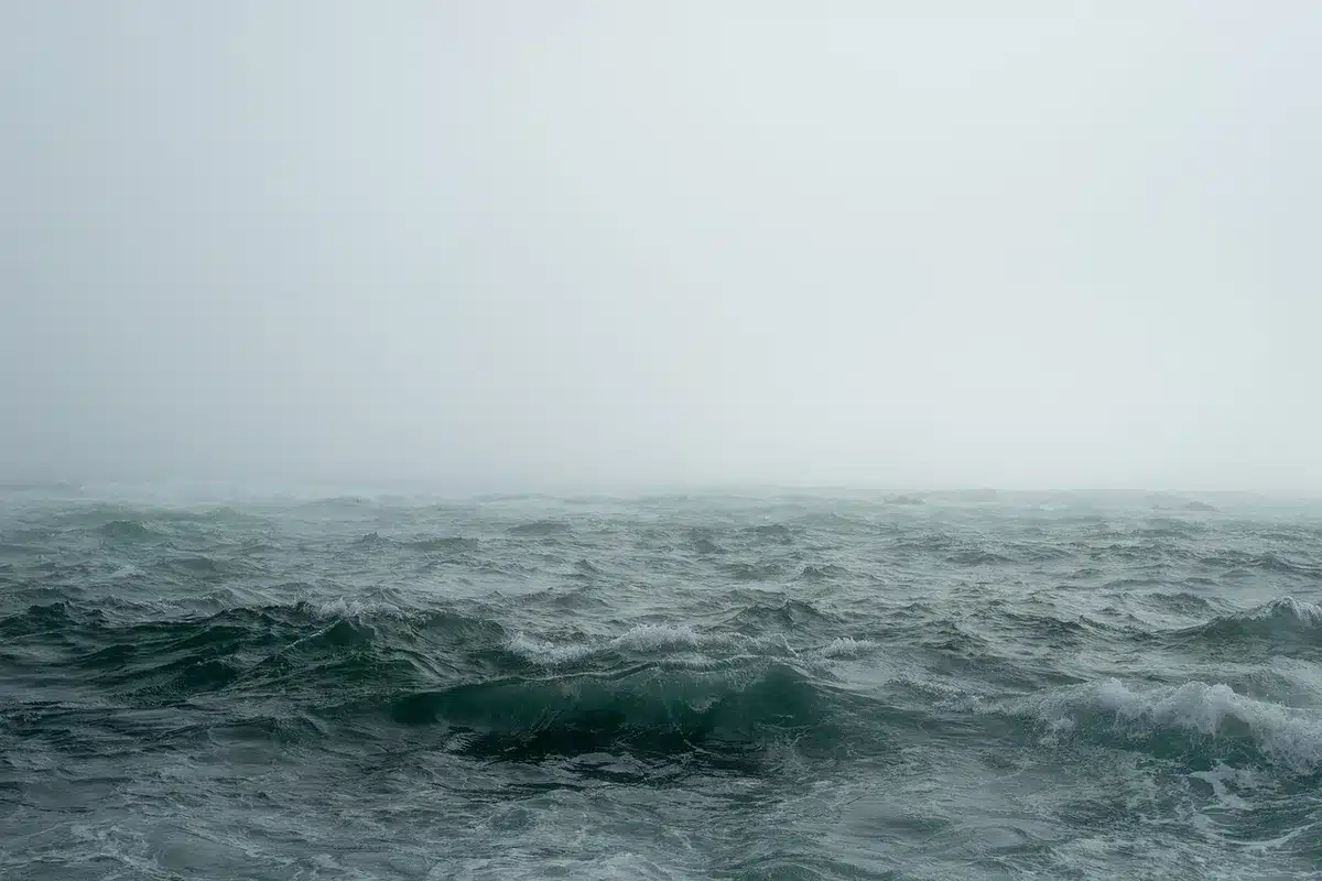 Offshore supply vessels near rocky islands under foggy sky, suggesting South Atlantic logistics tension