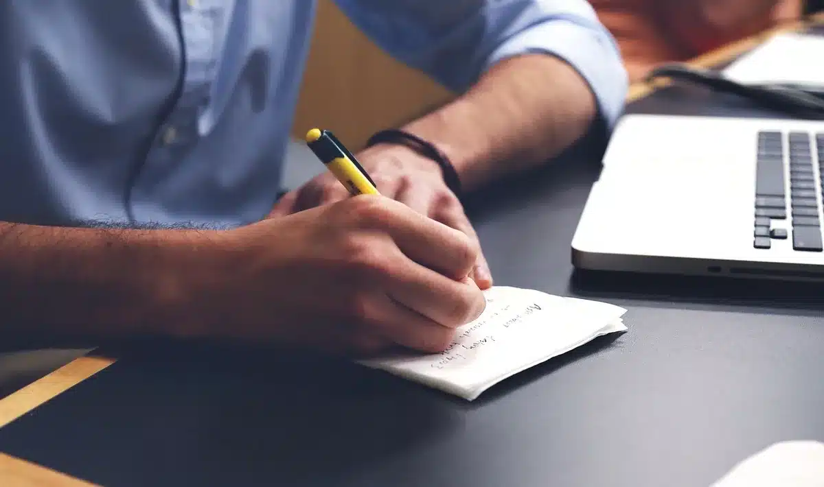 Professional writer creating educational content at desk with research materials