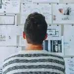 Professional workspace with data charts, research papers, and laptop showing analytics