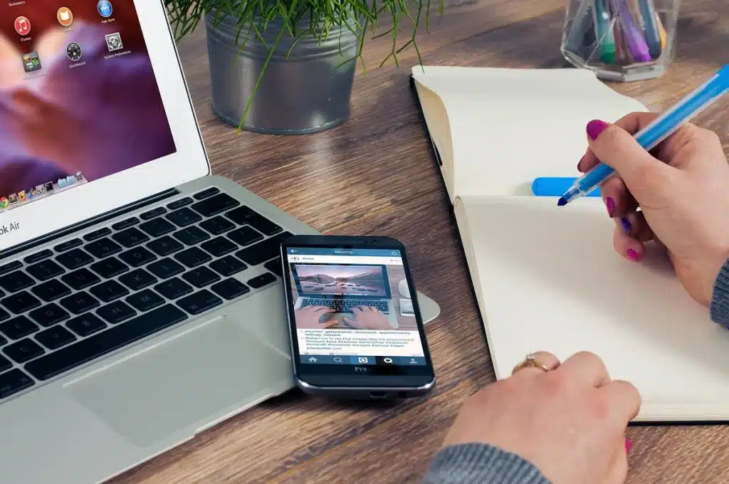 Laptop on a desk with blurred search results, notepad and coffee in a bright workspace