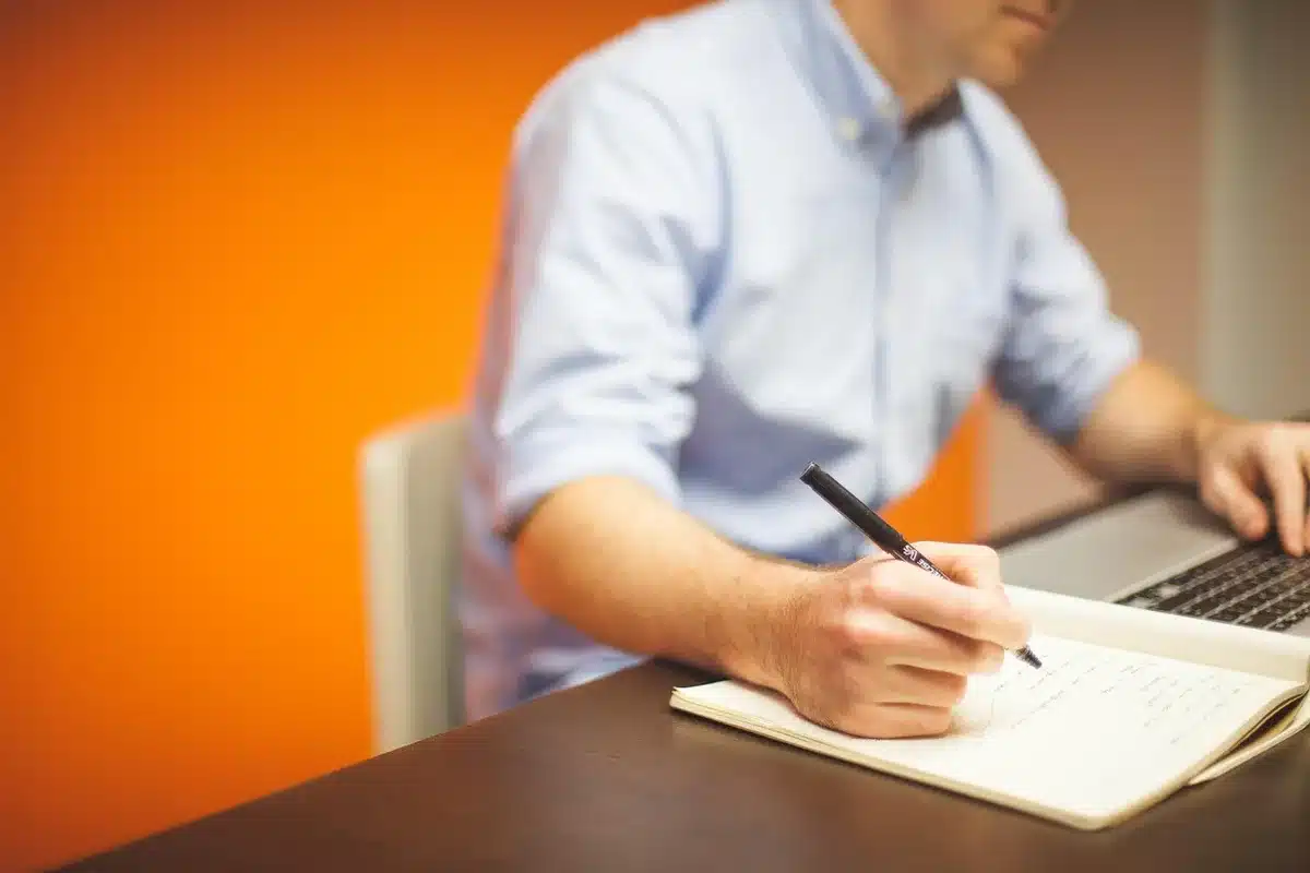 Person reviewing a content audit checklist on a laptop and notes