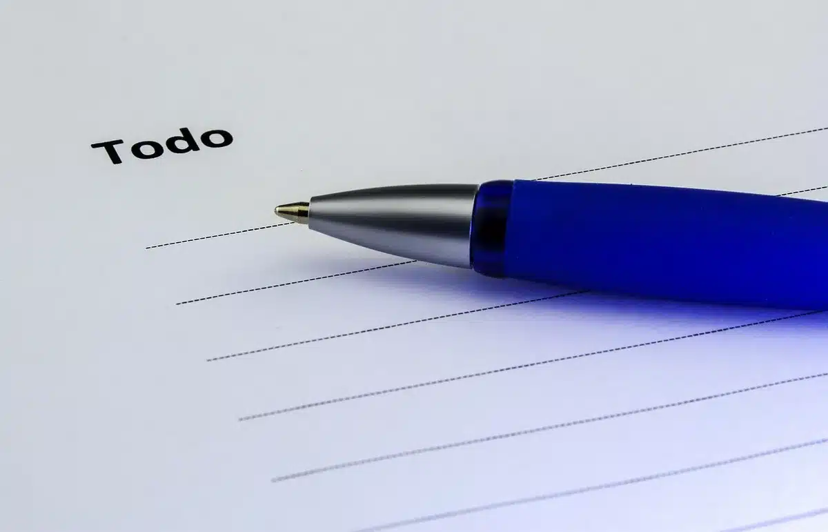 Printed checklist with keywords and notes next to a laptop