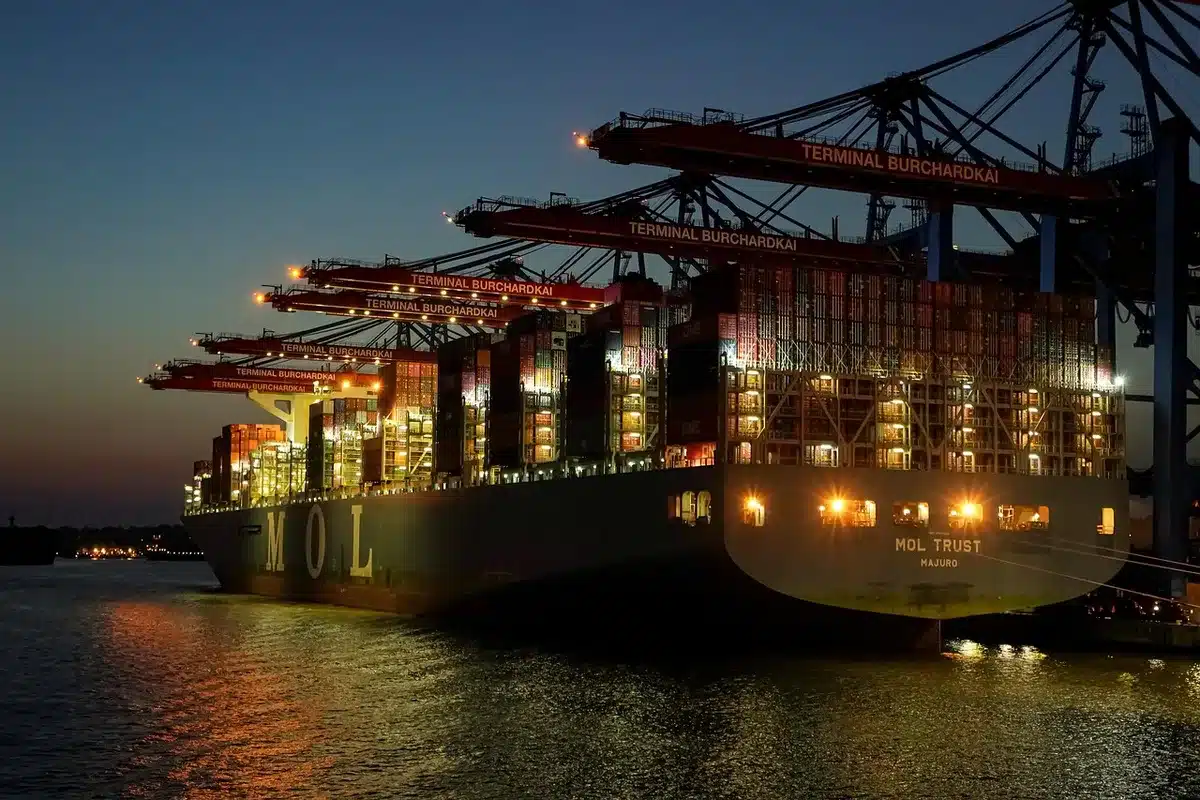 Stacked containers at a port illustrating shifting supply routes and logistics