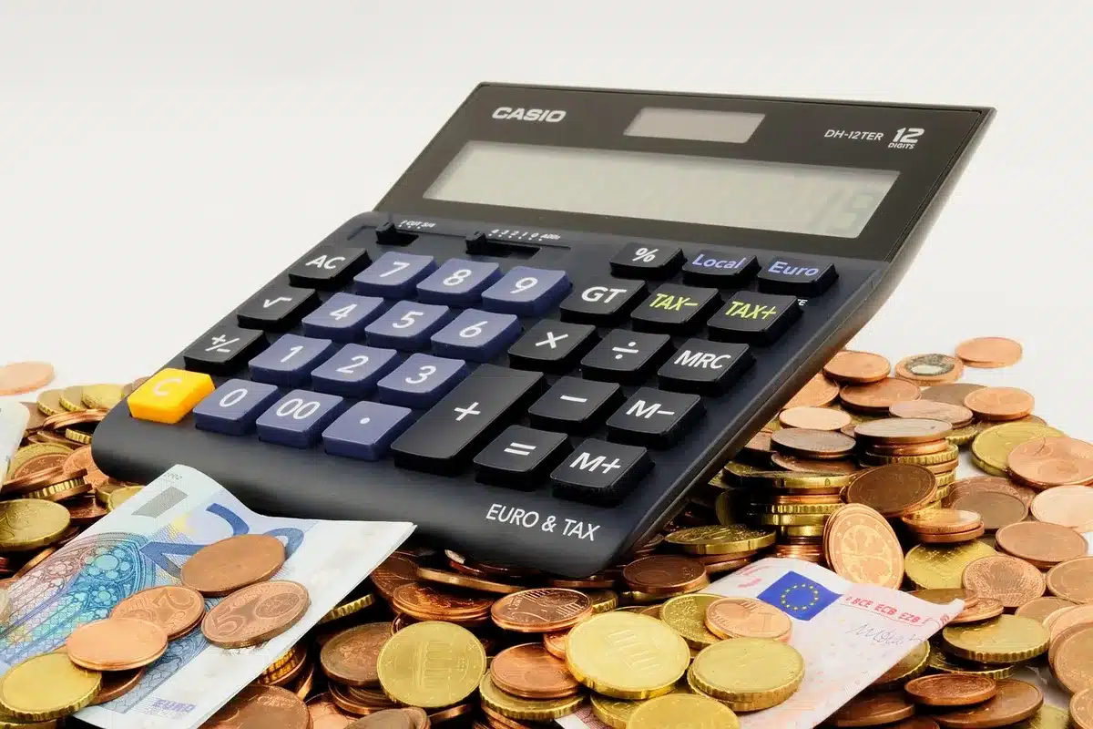 Person calculating household bills with receipts, showing rising living costs